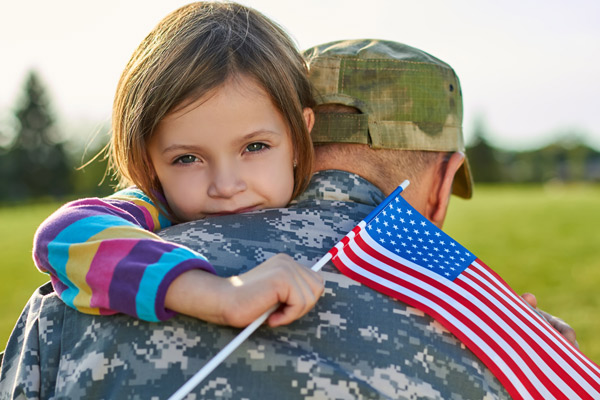 Child hugging soldier with american flag
